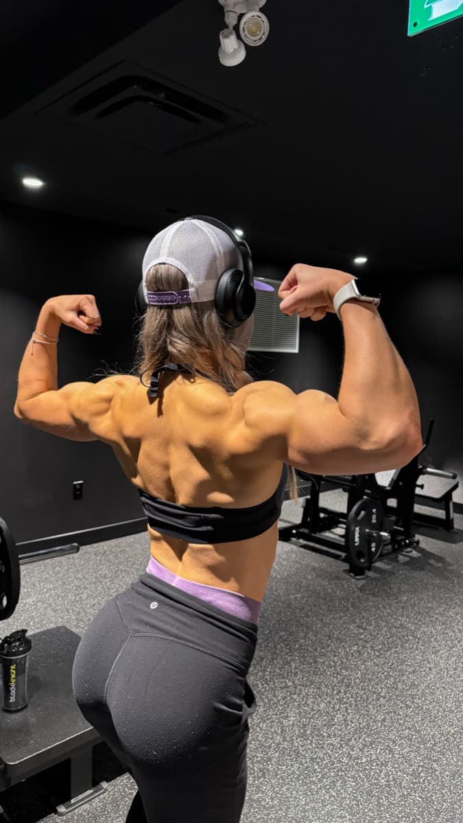 Hannah, back double biceps in the gym